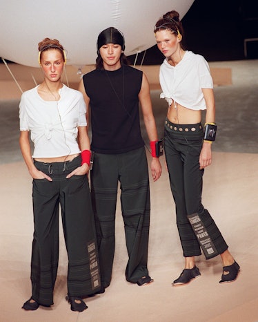 Three models display black and white outfits durin
