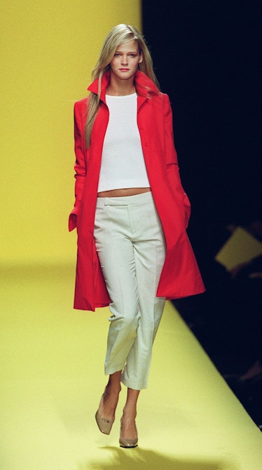 A model wears a red knee-length coat over a white