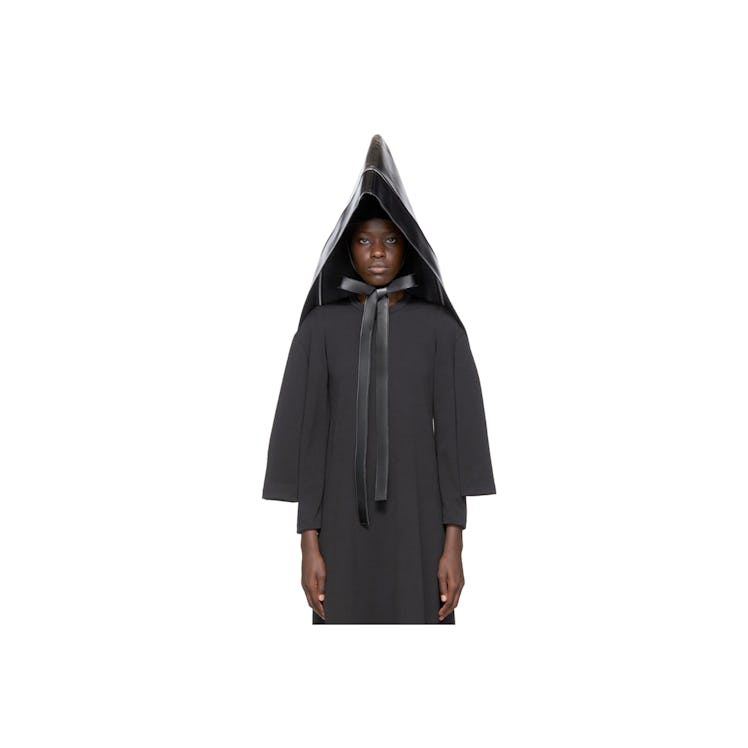 A model wearing a black faux leather oversized hood by Comme des Garcons