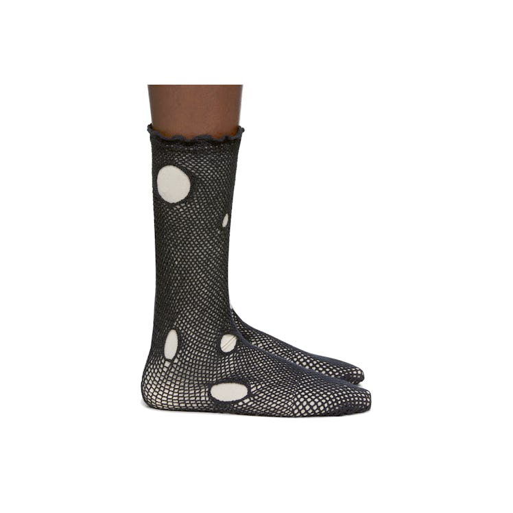 A model wearing black hole dot socks by Yohji Yamamoto