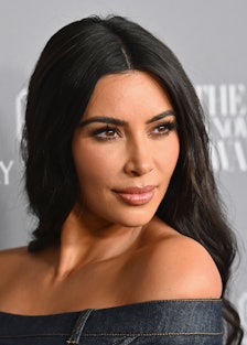 Kim Kardashian strikes a pose on a red carpet.