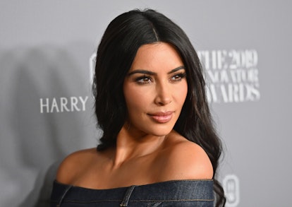 Kim Kardashian strikes a pose on a red carpet.