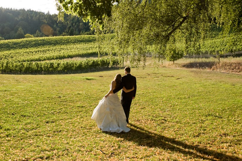 Newly Wed Couple Embracing Standing on Sunset