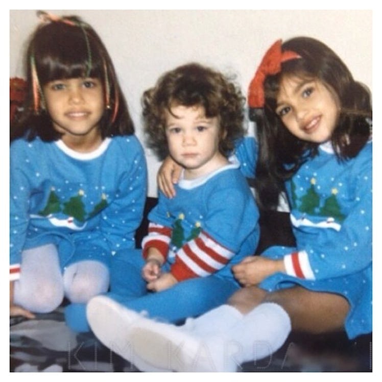 Young Kim, Khloe and Kourtney Kardashian posing in blue Christmas sweaters