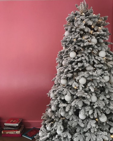 A Christmas tree with white ornaments next to a pink wall at Kendall Jenner's house