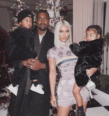 Kanye West holding Saint West and Kim Kardashian holding north West at Kris Jenner's Christmas party