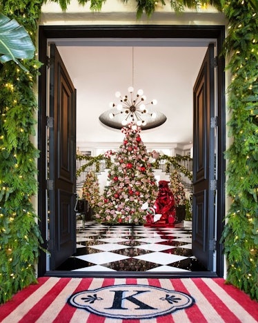 The decorated entrance of Kris Jenner's house during Christmas with a large K on the floor and a Chr...
