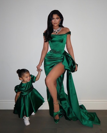 Kylie Jenner and Stormi Webster in matching sating green dresses during Christmas
