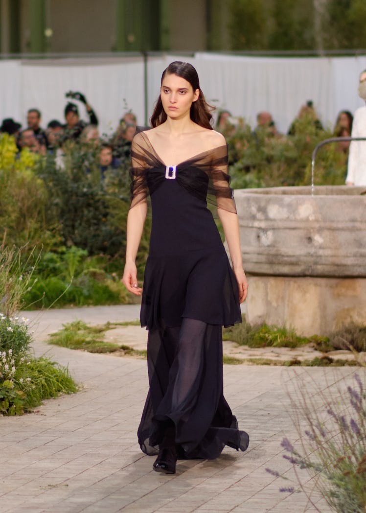 A model wearing a black tulle dress at the Chanel Couture Spring 2020 runway