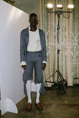 A model posing in a look representing a mix of the “baroque” and the “humble” from Telfar's Fall 202...