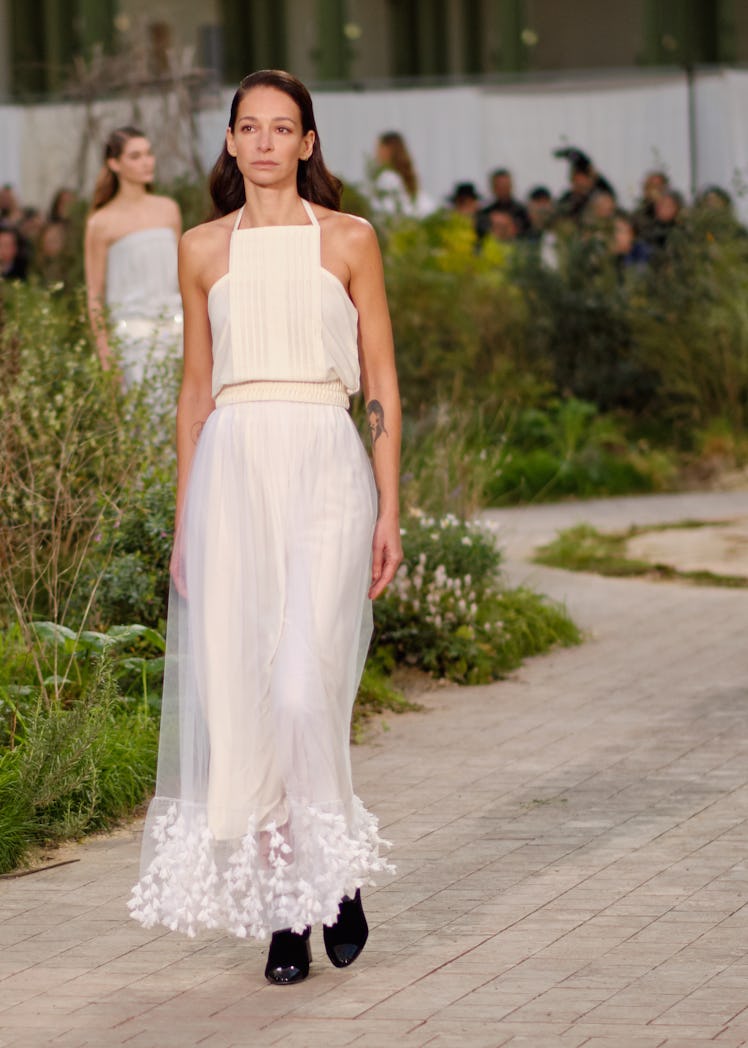 A model wearing a cream top and cream-white tulle skirt at the Chanel Couture Spring 2020 runway
