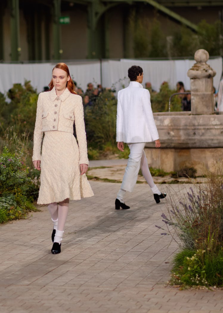 A model wearing a cream blazer and skirt at the Chanel Couture Spring 2020 runway