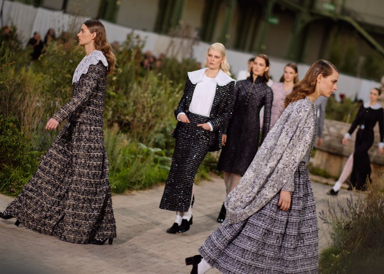 Several models walking in grey, black, and white outfits at the Chanel Couture Spring 2020 runway