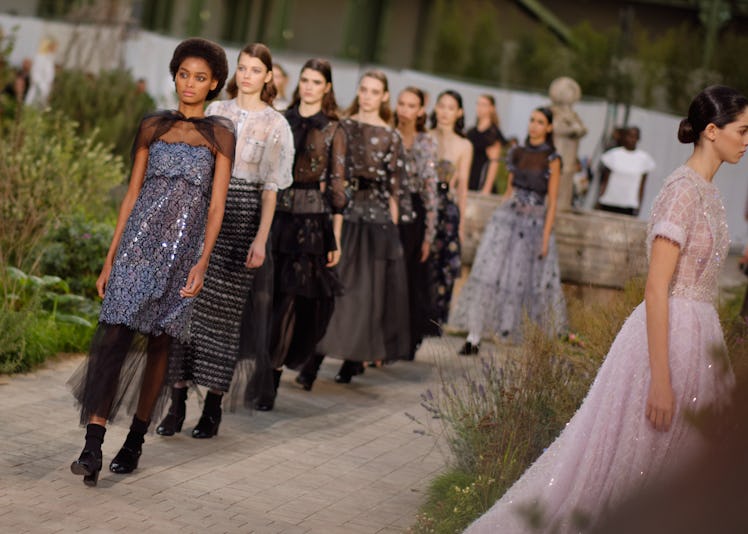 A row of models walking in a line at the Chanel Couture Spring 2020 runway