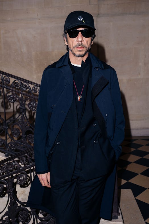 Pierpaolo Piccioli posing for a photo in a black cap and coat
