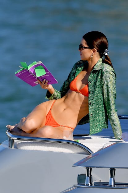 Kendall Jenner in Miami Beach, Florida wearing an orange swimsuit and a green shirt