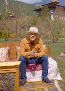 French shoe designer, Christian Louboutin sitting in a garden in Bhutan