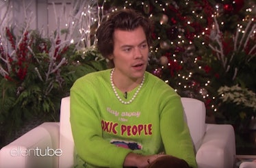Harry Styles wearing pearls and a fun green sweater during an appearance on the Ellen DeGeneres Show...