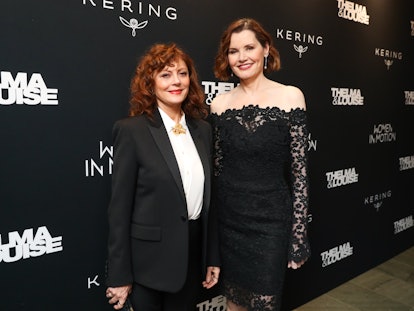 Susan Sarandon in a white shirt an black suit  and Geena Davis in a black lace dress at a red carpet...