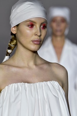 A model walking with red eye makeup at the Art School Fall 2020 show