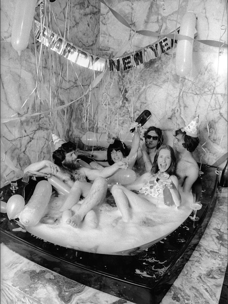 Group of girls lying together in an oversized bathtub