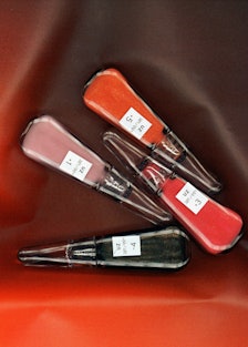 Four packages of UZ’s Self-Moisturizing Lip Treatment in pink, red, orange and black