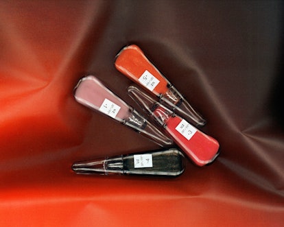 Four packages of UZ’s Self-Moisturizing Lip Treatment in pink, red, orange and black