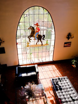 A view of the living room, an original stained glass of a vaquero in Bettina Korek's Los Feliz home