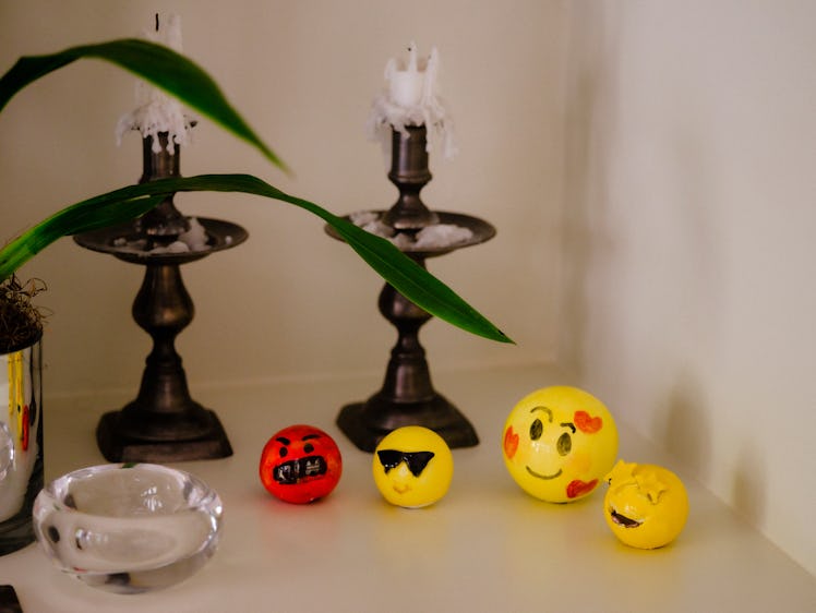 Two candleholders and small yellow emoji balls in Bettina Korek's Los Feliz home
