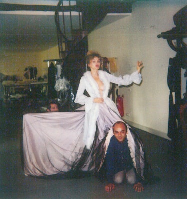  Arielle Dombasle in a white dress and Christian Louboutin posing while covered with a part of her d...