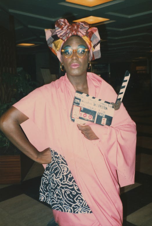 Smith on the set of his 1985 fashion film, Expedition, wearing a pink dress and multi-color headpiec...