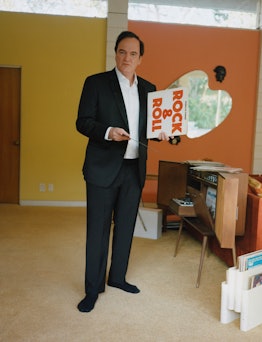 Quentin Tarantino wearing a Boss tux jacket, shirt, and pants at the party