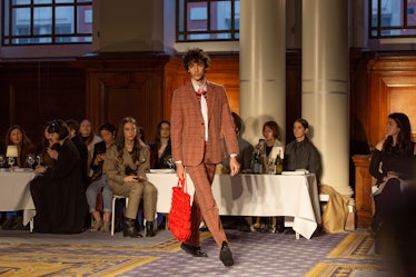 A model wearing an orange checked suit and a red bag at the Molly Goddard’s London Fashion Week Show