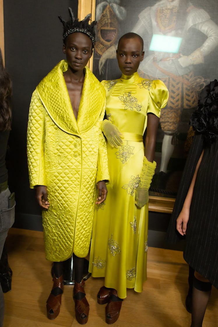 Two models posing in bright yellow outfits made by Erdem Moralıoğlu