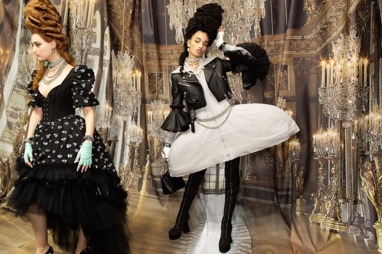 A model in a black dress and a model in a white dress and black jacket backstage at the Moschino Fal...