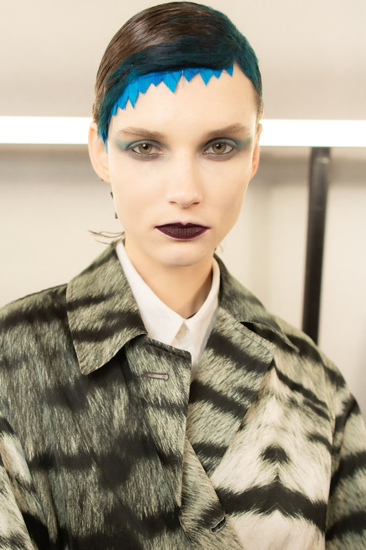 Closeup of a female model with black and blue hair and white makeup