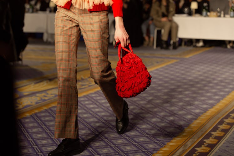 A model wearing a beige checked suit and a red bag at Molly Goddard’s London Fashion Week Show