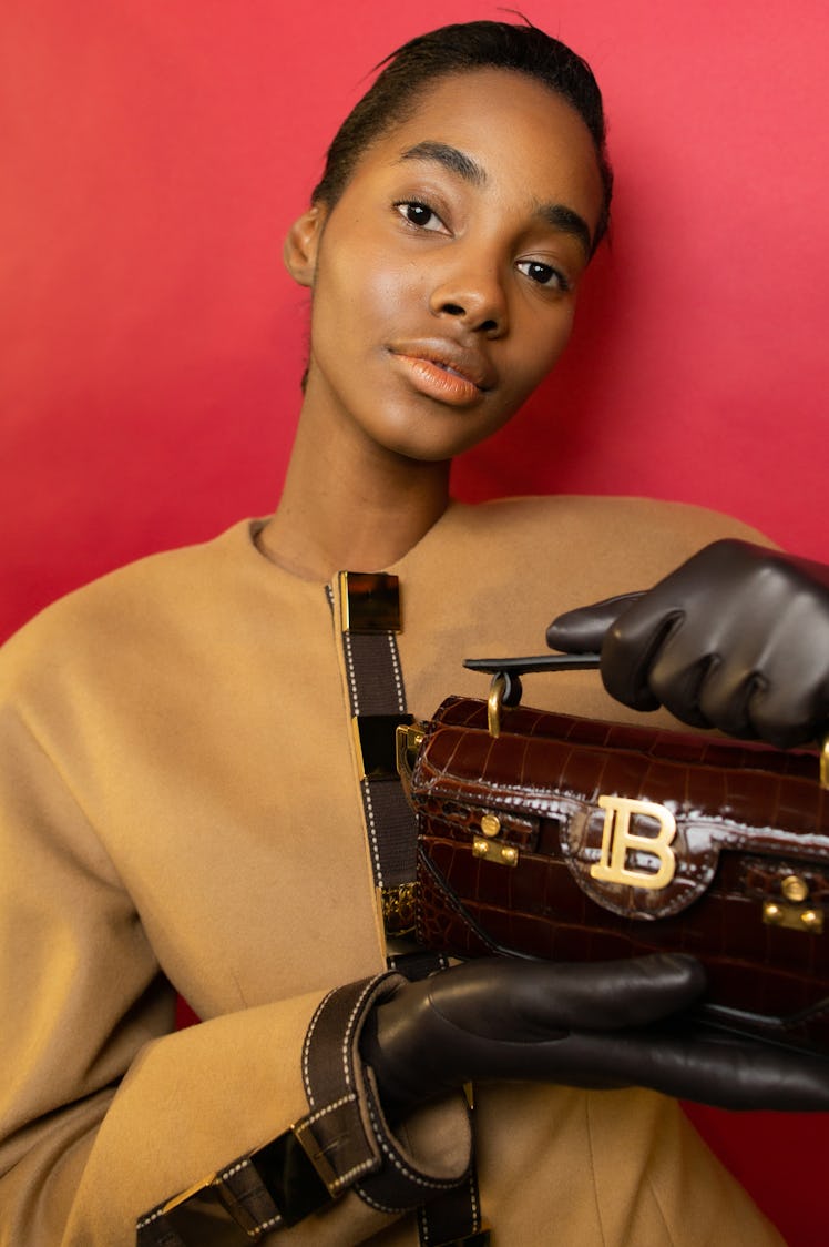 A model in a beige jacket and a small brown bag during Balmain Fall 2020