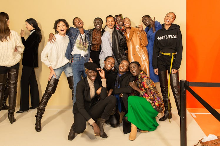 Models standing together and squatting and smiling backstage at Balmain Fall 2020