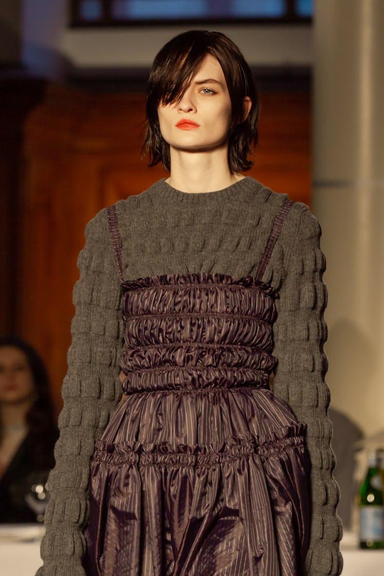 A model wearing a brown sweater and a brown puff dress at Molly Goddard’s London Fashion Week Show