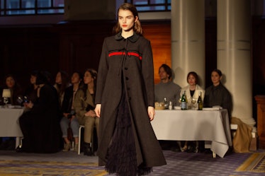 A model wearing a black coat with a red stripe at Molly Goddard’s London Fashion Week Show