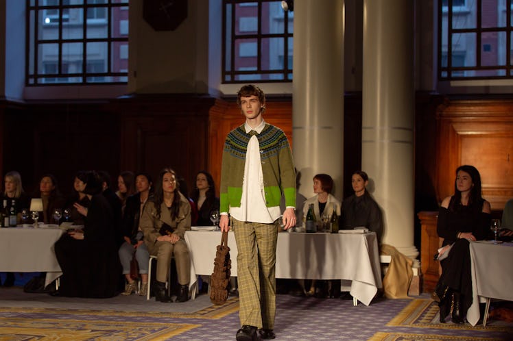 A model wearing a white shirt, a green cardigan and khaki trousers at Molly Goddard’s London Fashion...