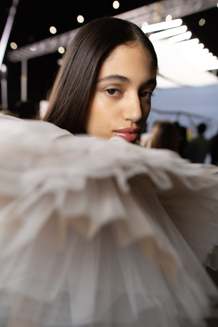 A model in a white tulle top backstage at Off-White