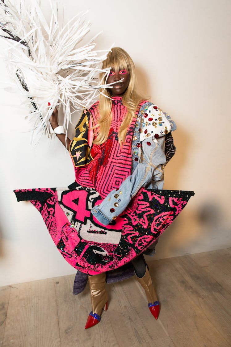 A model in a pink-black-white multi-patterned dress backstage at the Matty Bovan fashion show