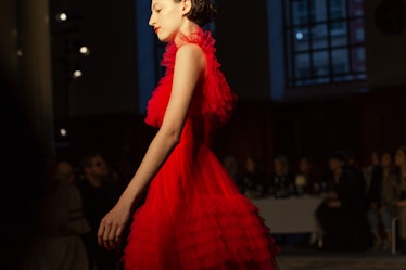 A model wearing a red frilled dress at Molly Goddard’s London Fashion Week Show