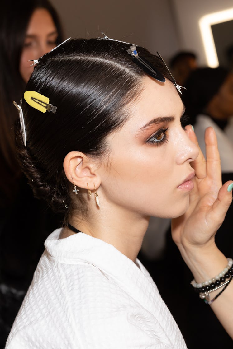 Model getting her makeup done in backstage at a fashion show