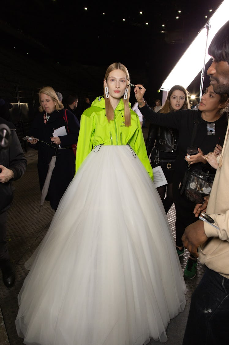 A model in a lime jacket and a white tulle skirt backstage at Off-White