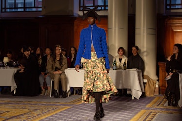 A model wearing a blue jacket and beige floral dress at Molly Goddard’s London Fashion Week Show