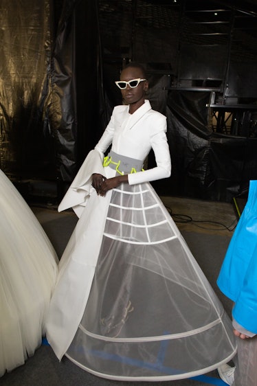 A model in a white dress with sheer skirt backstage at Off-White