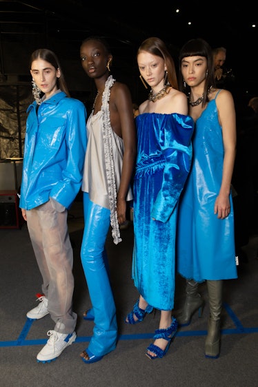 Four models in blue, silver and grey outfits backstage at Off-White